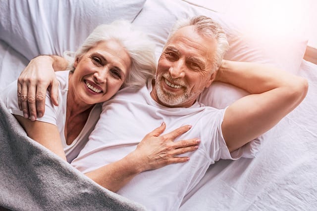 Happy Couple In Bed - Aging The Healthy Way